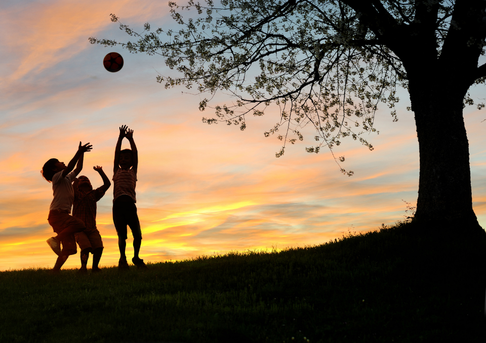 drei spielende Kinder im Abendhimmel